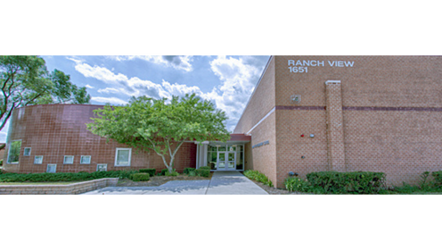 Ranch View Elementary School Building. Large brick building with green trees in front to the left. 